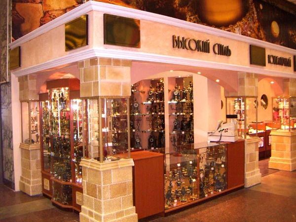 Mall jewelry kiosk with stone columns, glass counters and tall display cabinets.